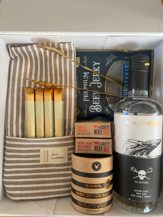 Kitchen apron, bootleg beef jerky, crafty weka mini bites x2, whittakers sante bars x4, olssons gin salts, copper serving tongs, Imagination seven seas gin, all packaged in a beautiful magnetic box with ribbons and personalized message, Gratefully gifted Christchurch new zealand 